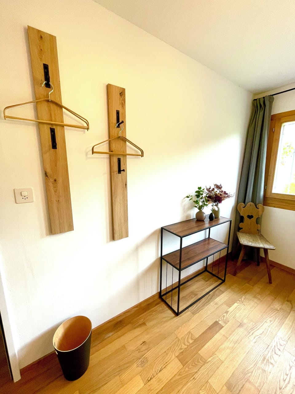 Bright entry nook with coat hooks, console table, and natural light