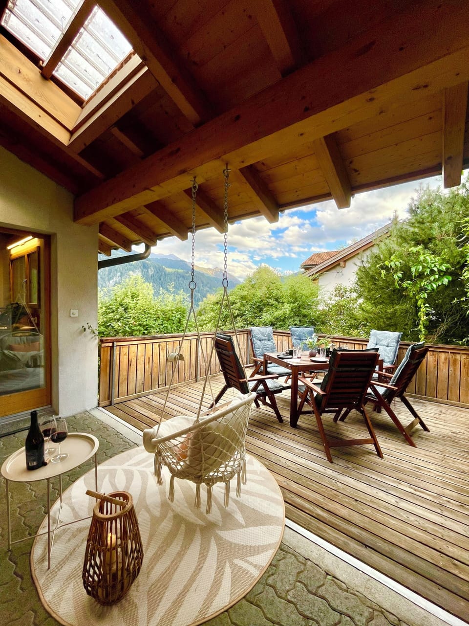 Covered mountain-view terrace with dining area and cozy hanging chair