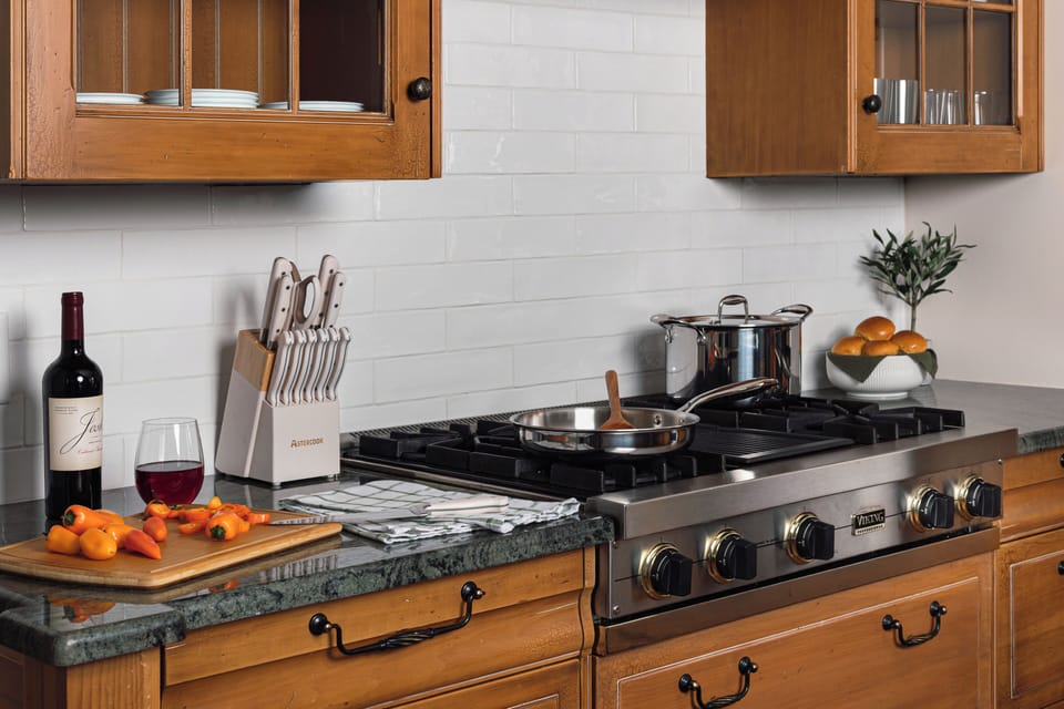 Chef-ready kitchen with gas range, stone counters, and warm wood cabinetry
