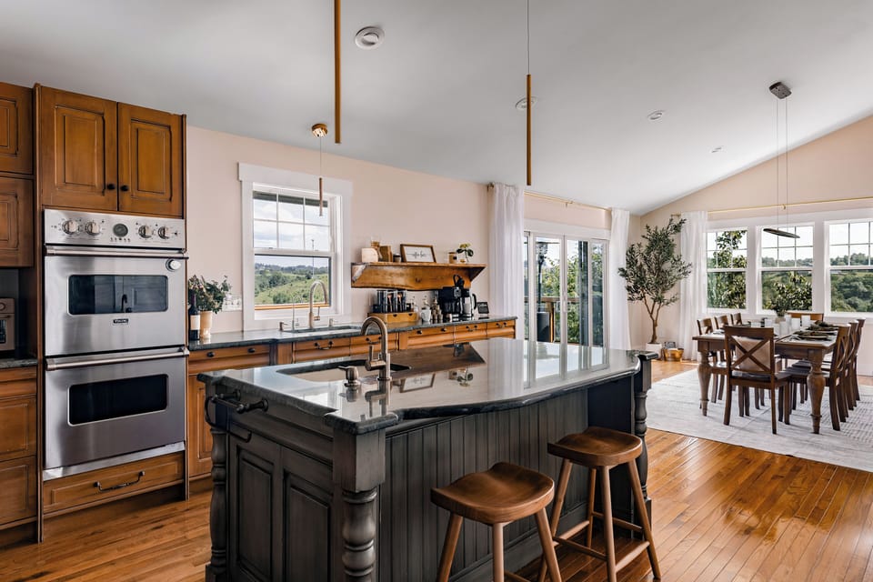 Bright gourmet kitchen with island seating and scenic dining views