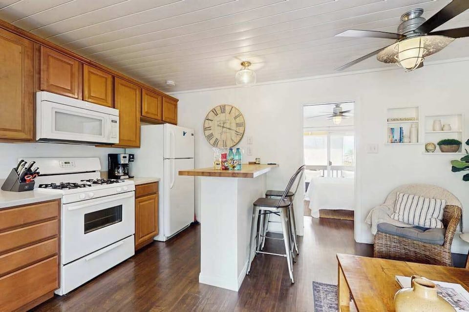 Fully Equipped Kitchen with Gas Range, White Appliances & Breakfast Counter