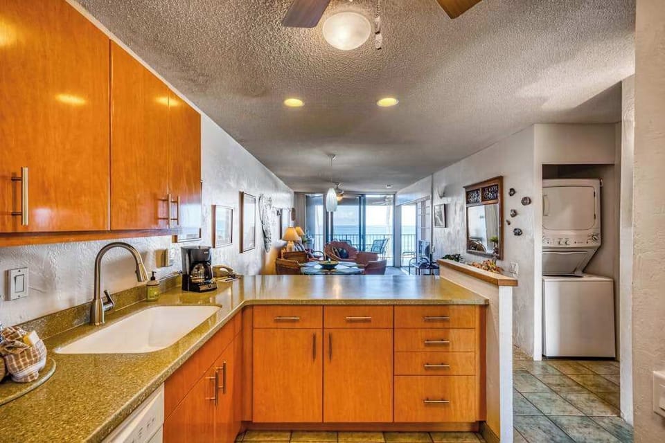 Functional kitchen counter and sink overlooking the spacious, open-concept living area
