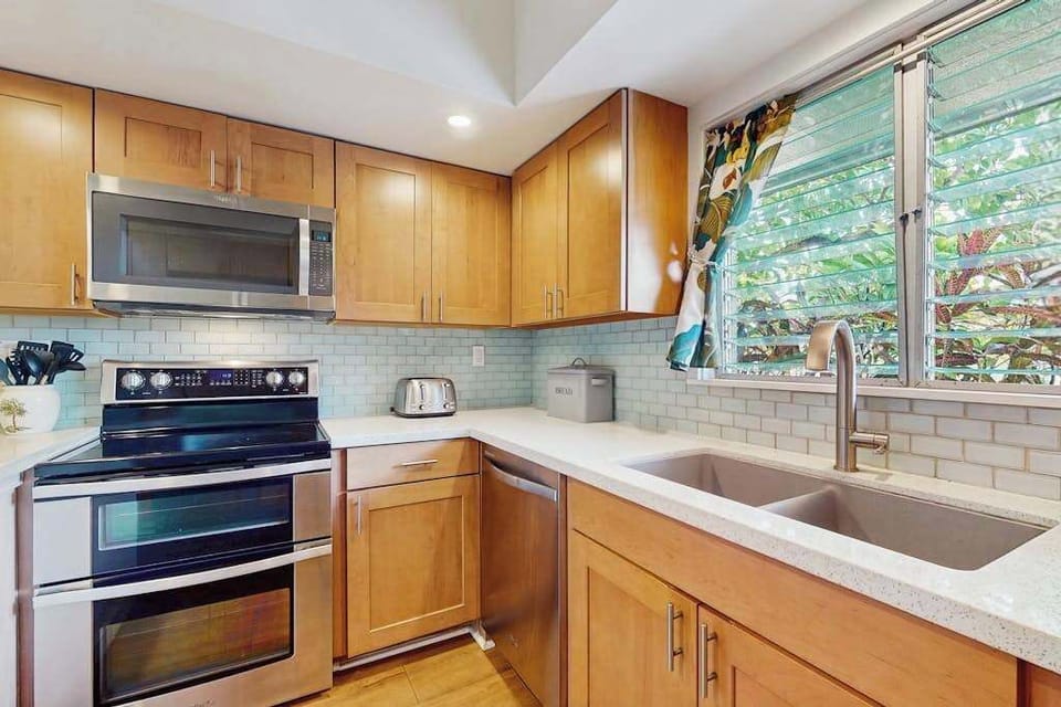 Contemporary kitchen showcases sleek cabinetry, cooking essentials, and organized countertops