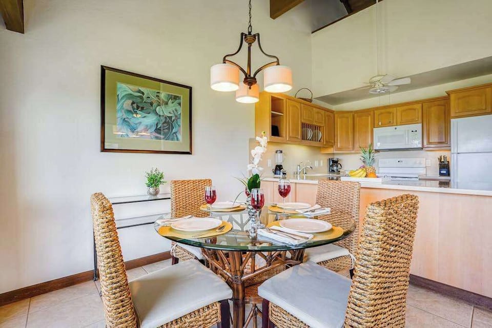 Glass-Top Dining Table with Wicker Chairs & Overhead Modern Chandelier