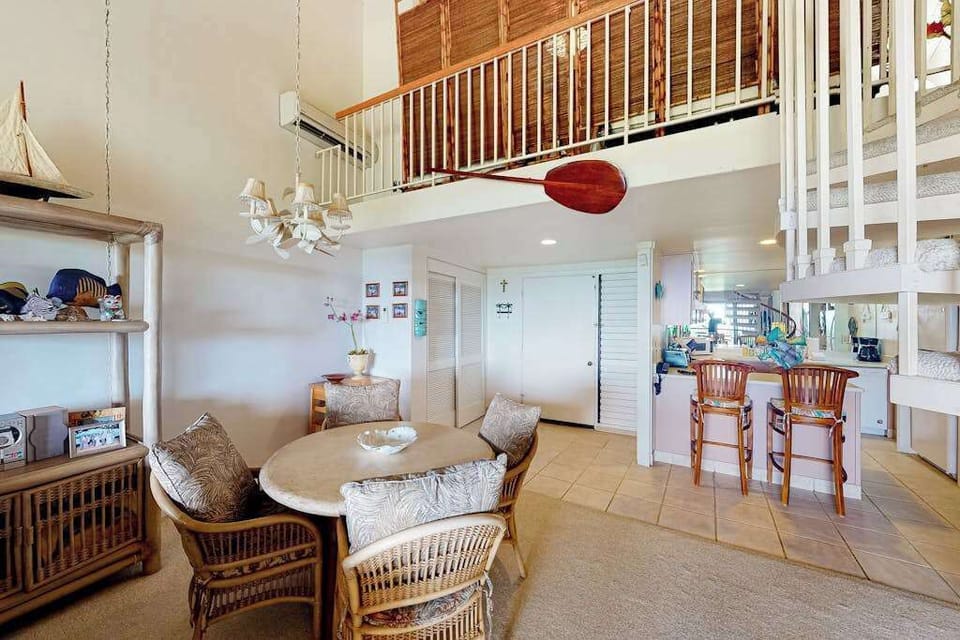 Living room features wicker seating dining table and mountain views