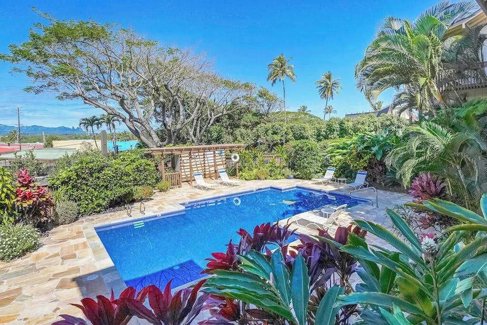 Resort-style pool surrounded by lush tropical gardens