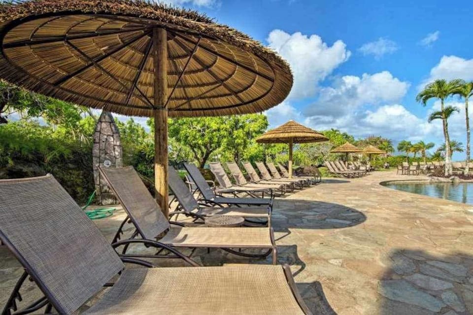 Poolside loungers beneath thatched umbrellas invite relaxing island afternoons outdoors