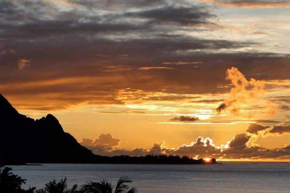 Watch breathtaking sunset colors brighten the sky above peaceful waters