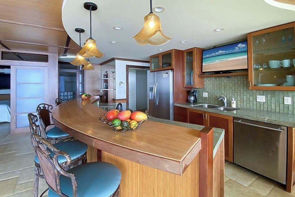 Open air kitchen and large island for extra counter space and four barstools for extra seating. 