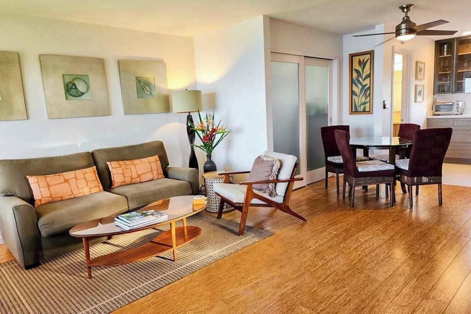Comfortable living room flows into dining space beneath ceiling fans