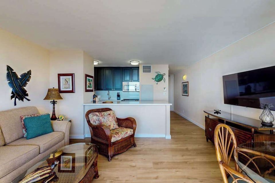 Bright living room with direct access to the private lanai, where beach views and swaying palm trees await.  With a flat screen TV for a little relaxation after a long day on Maui.