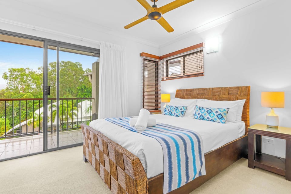 Wake to leafy outlooks from the primary bedroom, featuring a king bed and direct access to a private balcony that welcomes the morning breeze.