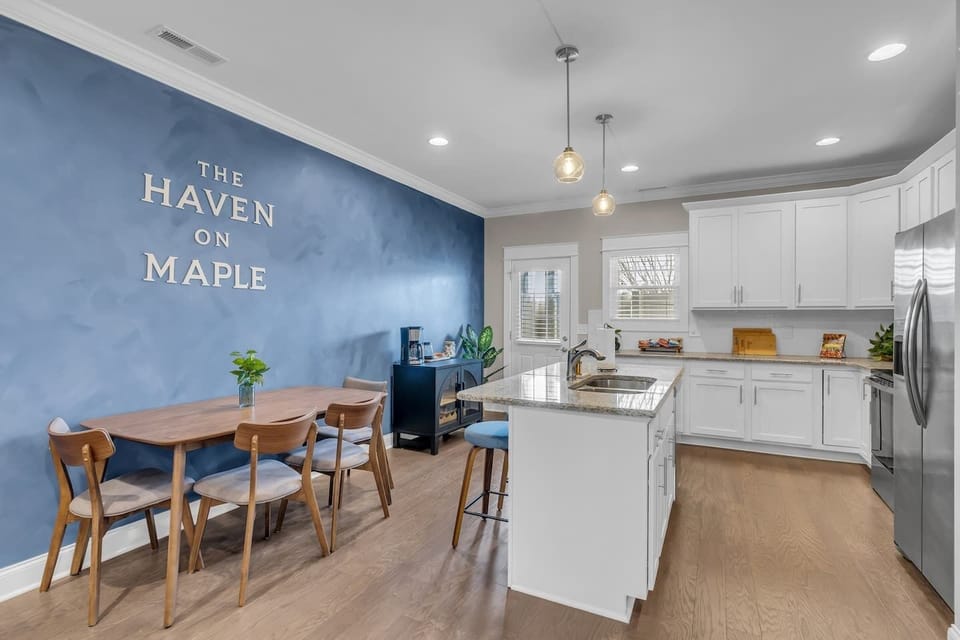 Kitchen features a table that seats 4, and there are three bar stools at the island.