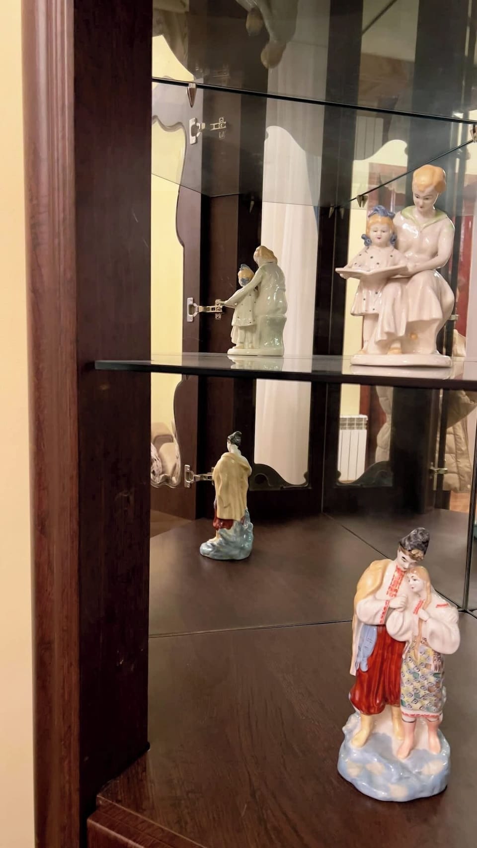 Elegant glass cabinet with porcelain figurines adds vintage charm to the space