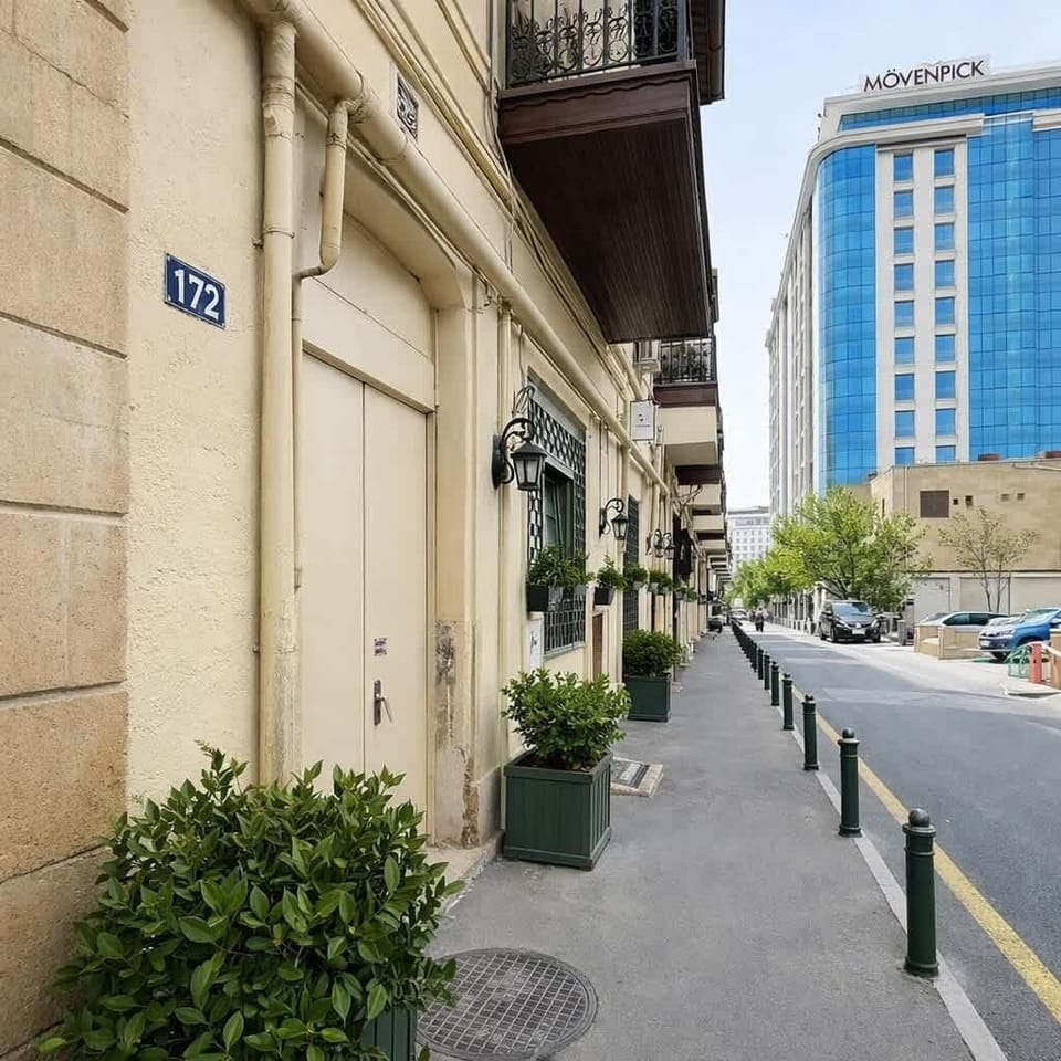 Chic city base on a quiet street with balconies and greenery.