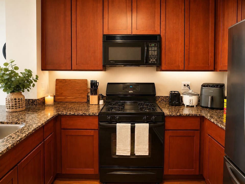 Warm granite kitchen with gas stove, microwave, and ample counter space