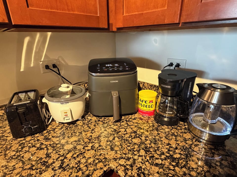 Well-equipped kitchen counter with air fryer, coffee maker, and more
