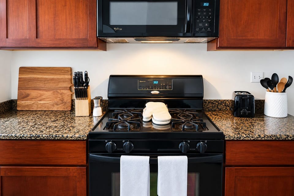 Well-equipped kitchen with gas stove, granite counters, and warm wood cabinets