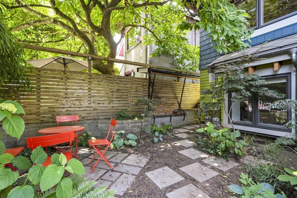 Charming Patio Retreat: Enjoy vibrant outdoor dining surrounded by lush greenery!