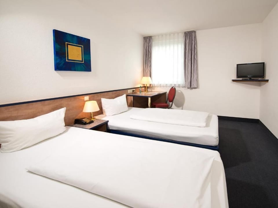 Unwind in bright twin room with cozy lamps and TV.