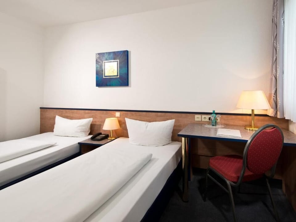 Catch up on work at the desk beside soft, restful beds.