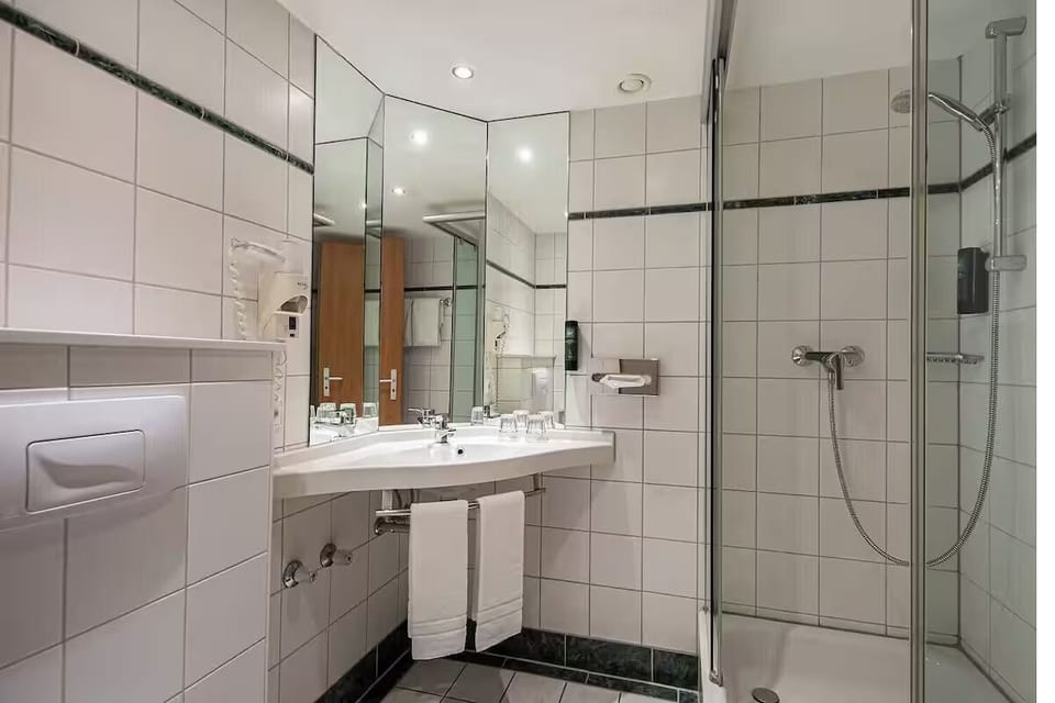 Refresh under a hot shower in a spotless tiled bathroom.