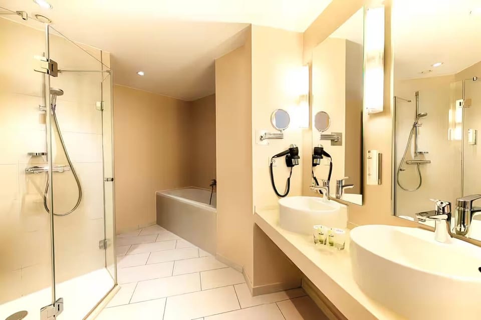 Refresh under a glass rain shower, then unwind in the tub.