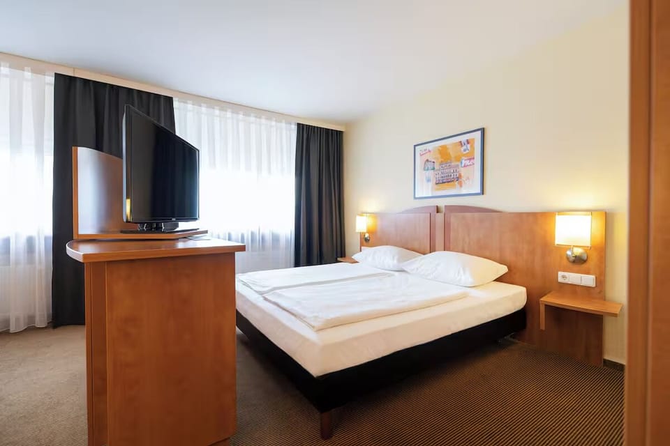 Unwind in a bright bedroom with cozy lamps and TV.