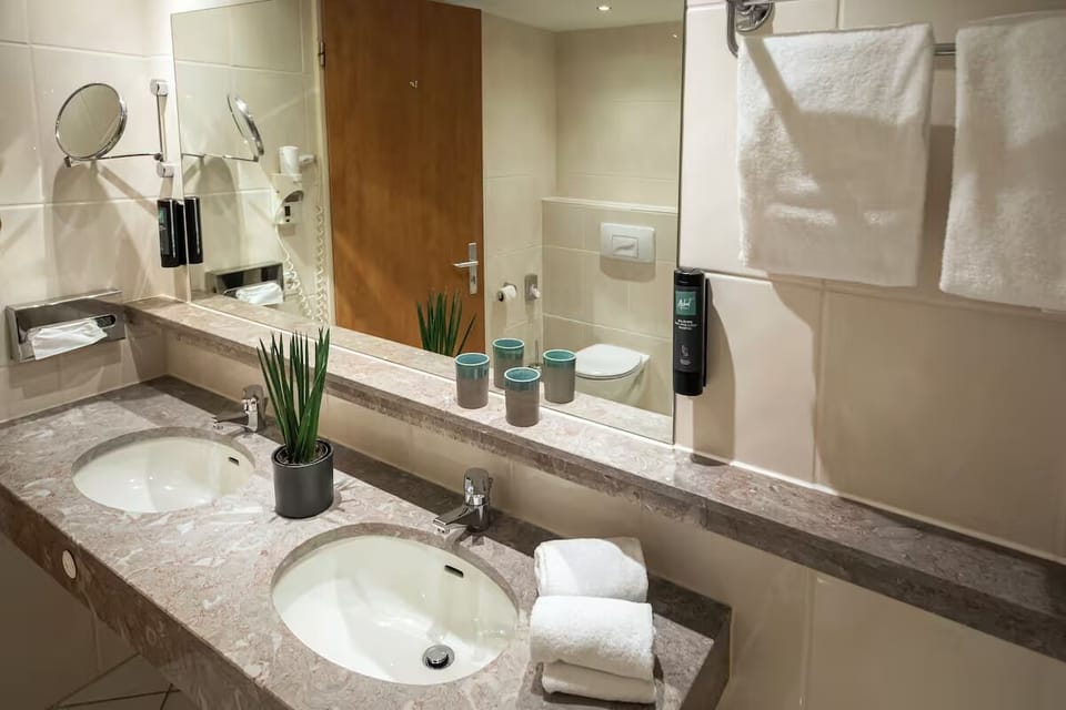 Refresh at the double vanity with plush towels and bright lighting.