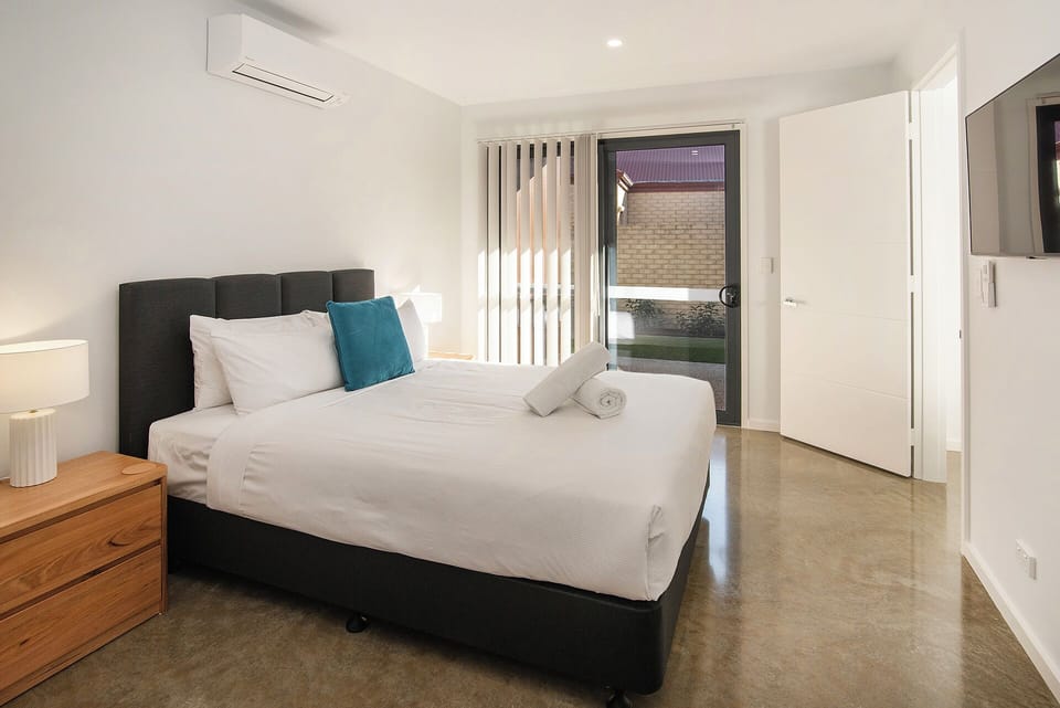 Bright modern bedroom with AC, natural light, and direct outdoor access