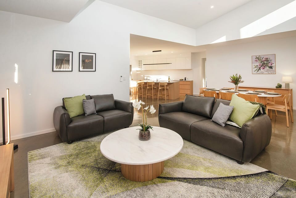 Bright open-plan lounge with stylish seating, dining area, and modern kitchen