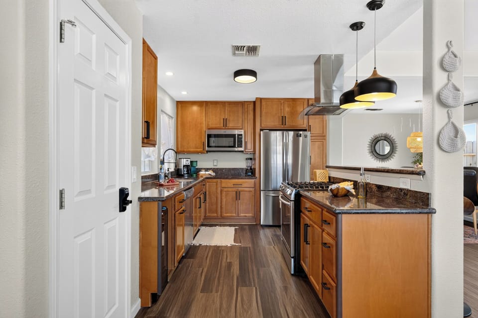 Features rich wood cabinetry, high-end stainless steel appliances, a professional range hood, and sleek granite countertops.
