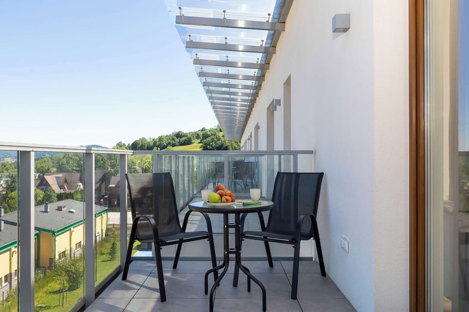 Private balcony furnished with outdoor seating, perfect for enjoying fresh air and mountain views.