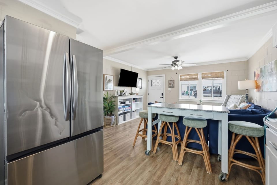 Gather around this inviting kitchen island with comfy seating while you prepare meals with modern stainless-steel appliances. Natural light fills your space, creating a warm atmosphere for cooking and connecting.