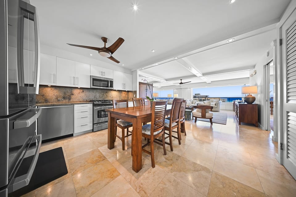 The open kitchen and dining area flow seamlessly into the living space, making it easy to gather for meals after a day at Kaimana Beach.