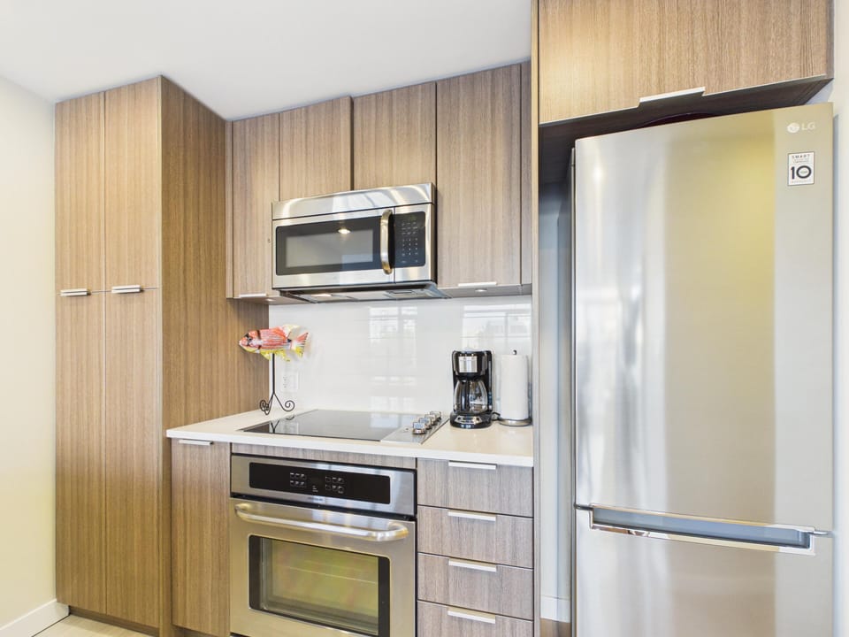 The fully equipped kitchen features premium, high-end stainless steel appliances and flat-panel cabinetry.