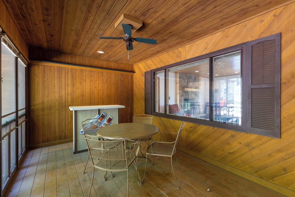 Screened in porch on the front of the house. Seating for four and bar top