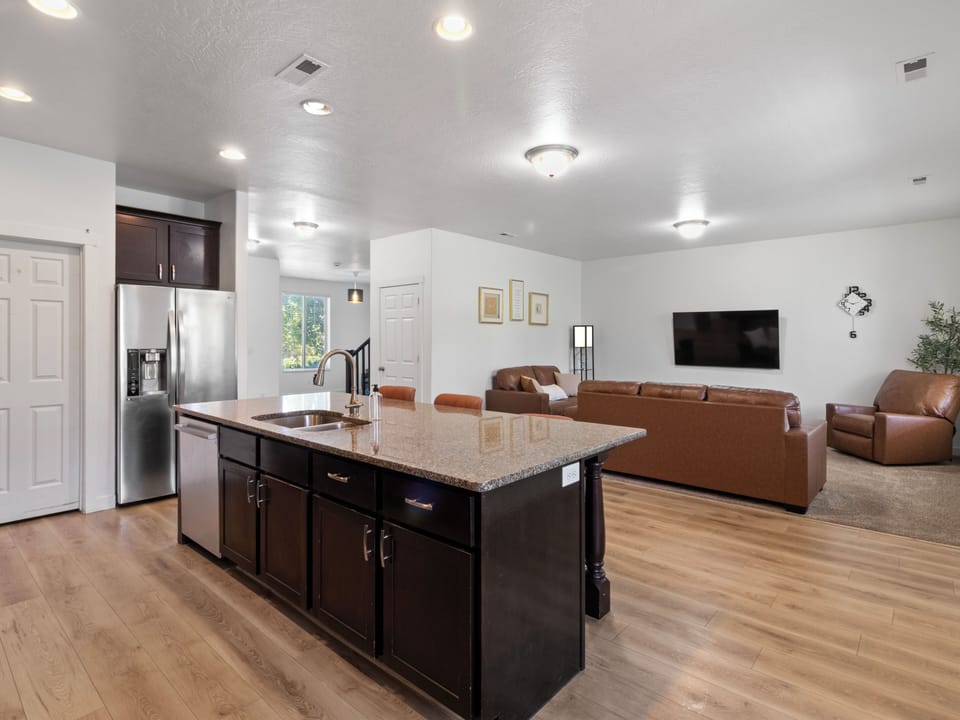 Bright main living space showing the open layout from kitchen island through to lounge seating and entertainment.
