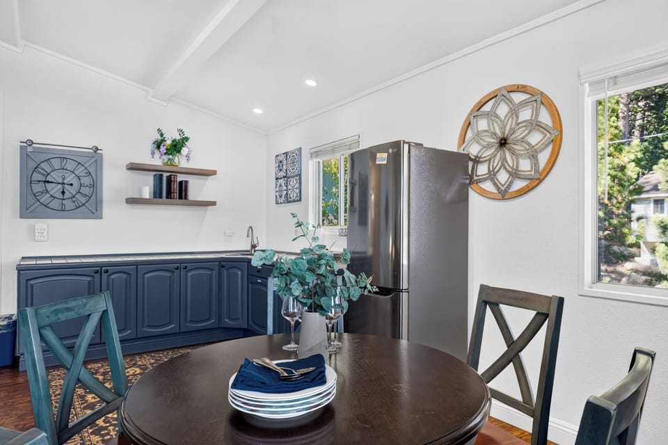 Bright dining nook with kitchenette, full-size fridge, and lake house-inspired blue accents.