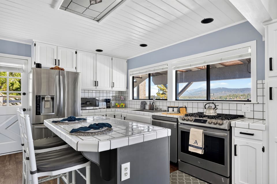 Bright kitchen with lake-view windows, stainless steel appliances, and island seating.
