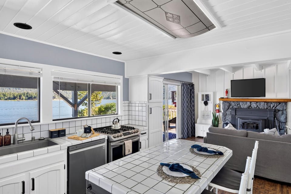 Bright lake-view kitchen with white cabinetry, stainless steel appliances, and plenty of prep space.