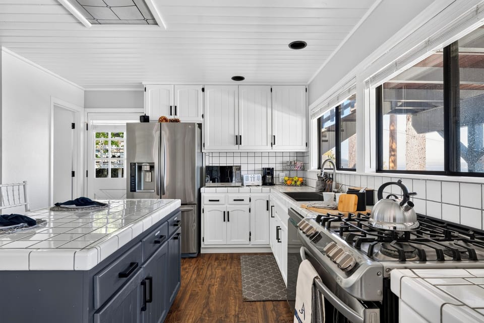Bright lake-view kitchen with white cabinetry, stainless steel appliances, and plenty of prep space.
