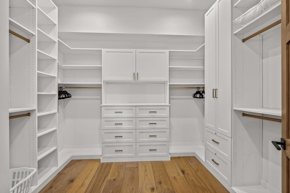 Walk into your spacious walk-in closet where custom shelving, hanging rods, and drawers keep your wardrobe perfectly organized and within reach.