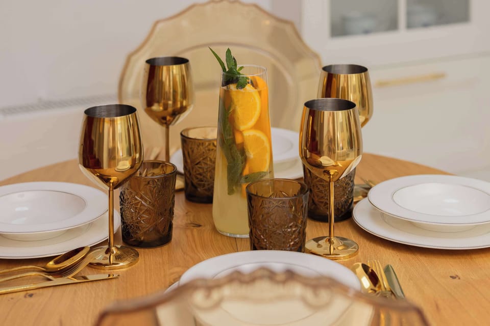 A close-up of the dining table showcases elegant tableware, gold accents, and decorative accessories. Carefully arranged place settings create a refined dining experience.