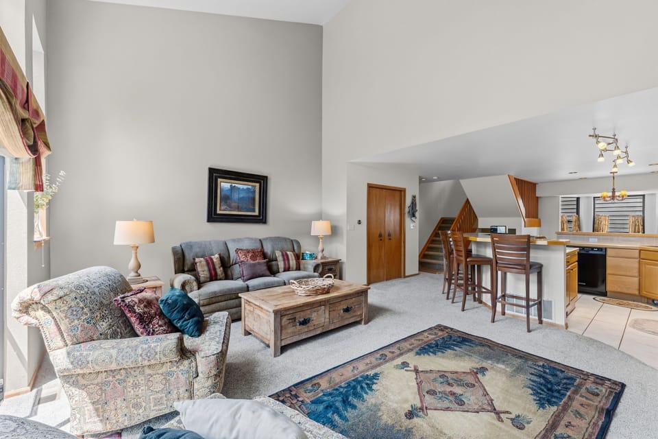 Settle in and relax in your spacious living area, complete with a cozy sofa and armchair perfect for unwinding after a day of adventure. The open-concept layout flows seamlessly into the kitchen and dining area, making it easy to feel at home.