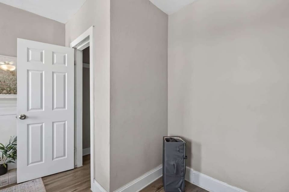 Neutral bedroom corner with easy access to the bathroom, closet area, and added guest storage.