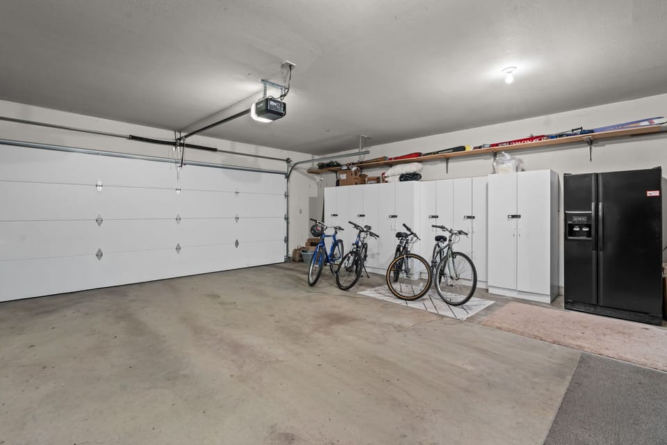 Spacious garage featuring organized storage, ready bikes for your adventures, and a refrigerator—perfect for easy beach prep and keeping your drinks cold after a day exploring.