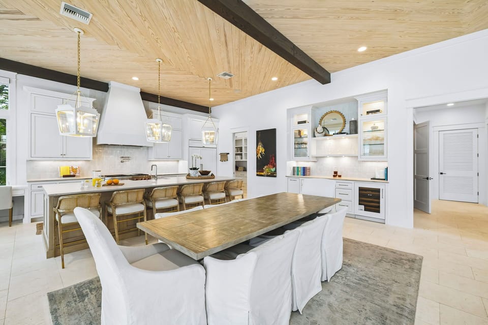 Your open-concept kitchen and dining space blends rustic warmth with modern elegance. Gleaming white cabinetry, a spacious island, and a long dining table invite memorable meals and easy conversation.