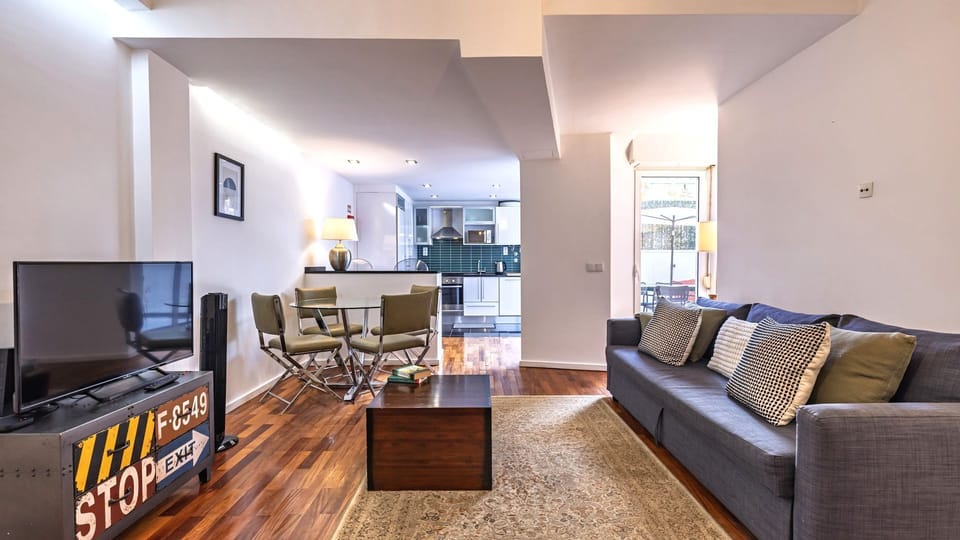 Relax in this bright open-plan living area featuring stylish décor, a cozy lounge, and seamless access to the outdoor patio. #LivingRoom #OpenPlanLiving #HomeAwayFromHome #LisbonStay #Portugal #PT #Lisbon
