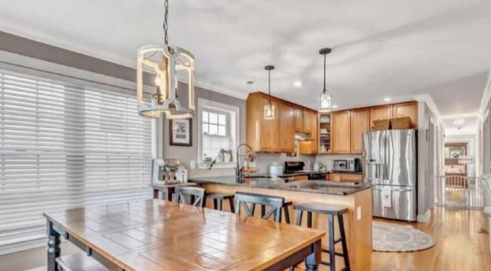Kitchen nook banquette and dining table w/seating for 7-10,  bar seating, espresso machine, coffee maker, air fryer, microwave, toaster oven, refrigerator, stove.